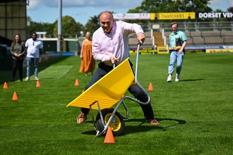  Davey takes part in a wheelbarrow race at Yeovil Town Football Club. Photograph: Finnbarr Webster/Getty Images