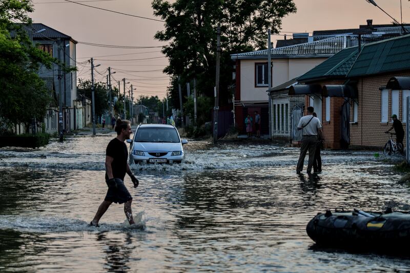 People walk in a flooded street of Kherson, Ukraine. A number of settlements were completely or partially flooded, Kherson's region governor said. Photograph: EPA-EFE