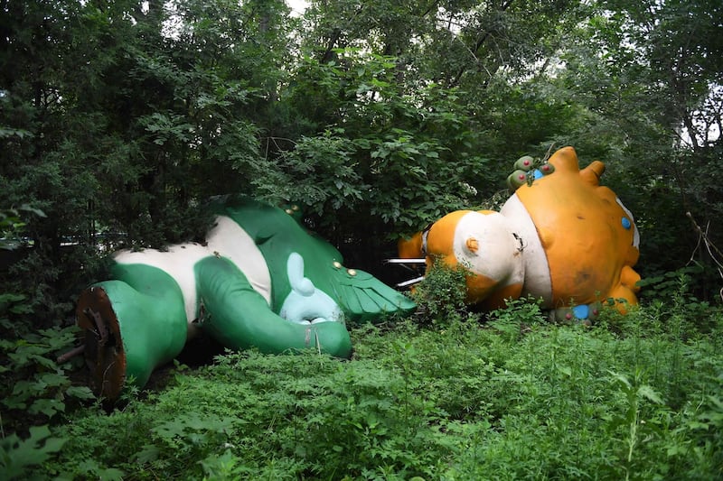 Nini (L) and Yingying, two of the five mascots for the 2008 Beijing Olympic Games, lying among trees behind an abandoned, never-completed mall in Beijing.  A decade after the city hosted the 2008 Olympics, its legacy remains unmistakable. For better or worse, the Games changed the face of Beijing: from the iconic Bird's Nest stadium to the blocks of ancient homes bulldozed in an Olympic building frenzy.  Photograph: AFP PHOTO / GREG BAKER