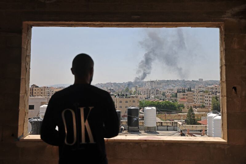 A Palestinian man looking on as smoke billows following an Israeli drone strike in Jenin on Monday. Photograph: Jaafar Ashtiyeh/AFP via Getty Images