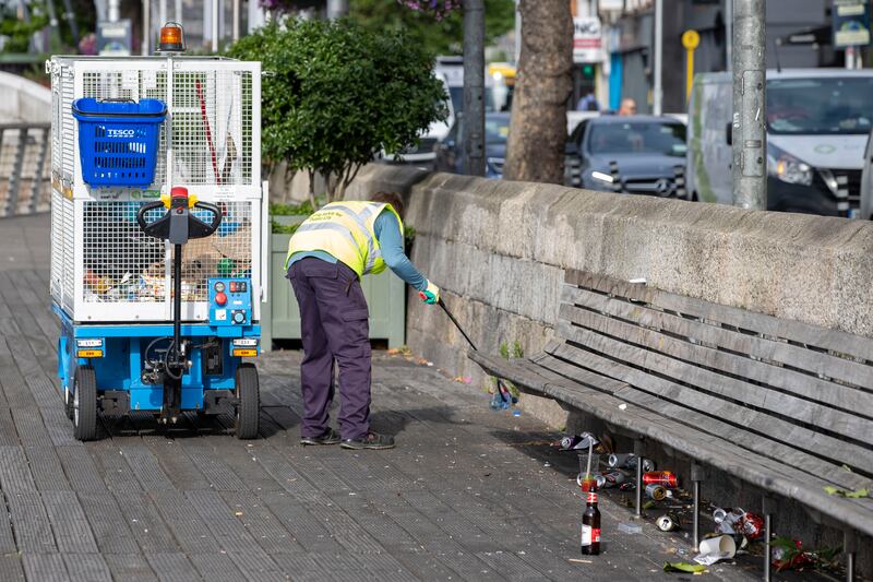 A Dublin City Council staff cleans litter on the Liffey Boardwalk, in Dublin. Photograph: Tom Honan