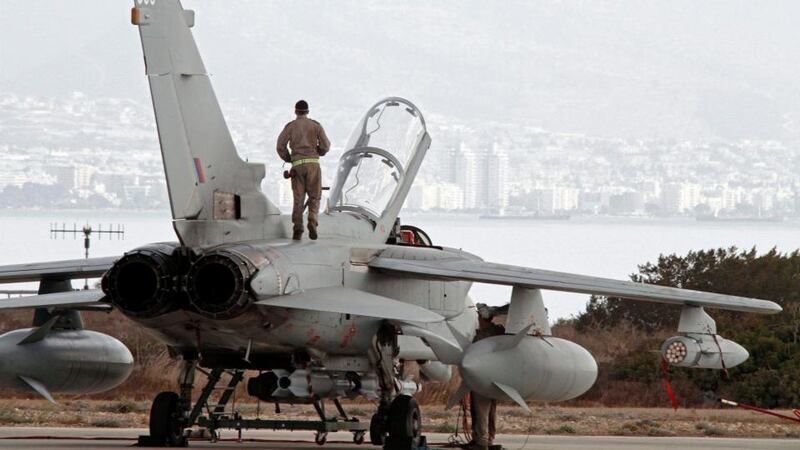 A British tornado fighter jet crew member stands on the jet at RAF Akrotiri in Cyprus this morning. The British ministry of defence (MOD) has confirmed that Royal Air Force jets have flown from RAF Akrotiri in Cyprus. Photograph: EPA