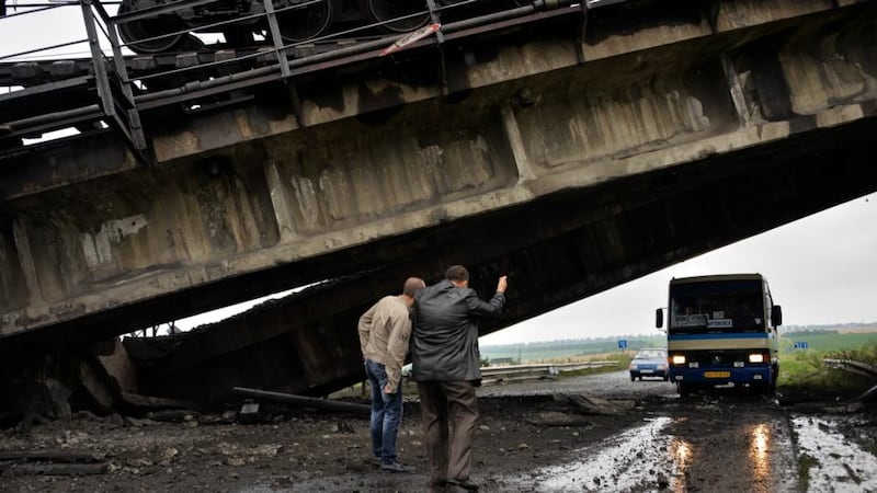 A bus drives under a rail bridge which was blown up  near  Donetsk recently. Photograph: EPA/STR.