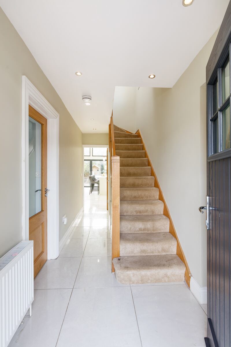 The hall is now bright and has porcelain tiles that run all the way through the living/kitchen area to the rear