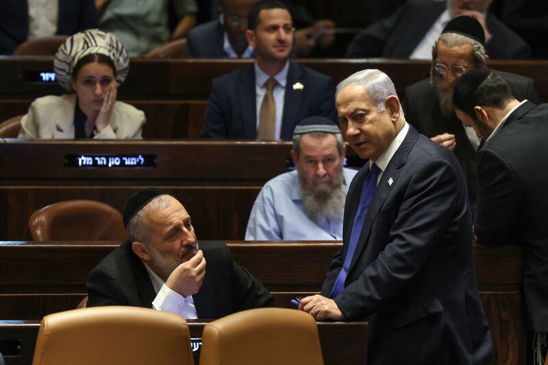 Israel's prime minister Benjamin Netanyahu speaks to Aryeh Deri, chairman of the ultra-Orthodox party Shas, on Tuesday ahead of the passing of a law which prevents the supreme court from overruling government actions it considers unreasonable. Photograph: Ronaldo Schemidt/AFP via Getty Images