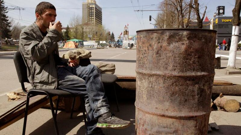 A pro-Russian protester drinks tea near the seized office of the SBU state security service in Luhansk, eastern Ukraine today.  Photograph: Reuters