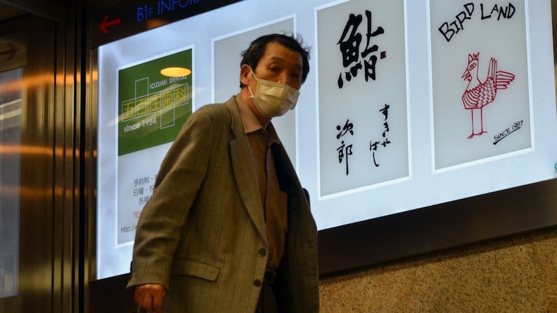 A man passes an advertisement board of Sukiyabashi Jiro in Tokyo. The restaurant  was stripped of its Michelin because it no longer opens to the general public. Photograph: Yoshikazu Tsuno/AFP via Getty Images