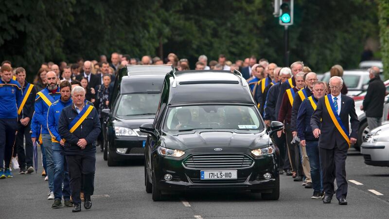 The cortege makes its way to  St John’s Church, Killenard,  flanked by family  and members of O’Dempseys GAA Club at the joint funeral of brothers, Fergus and Philip Brophy. Photograph: Colin Keegan, Collins Dublin