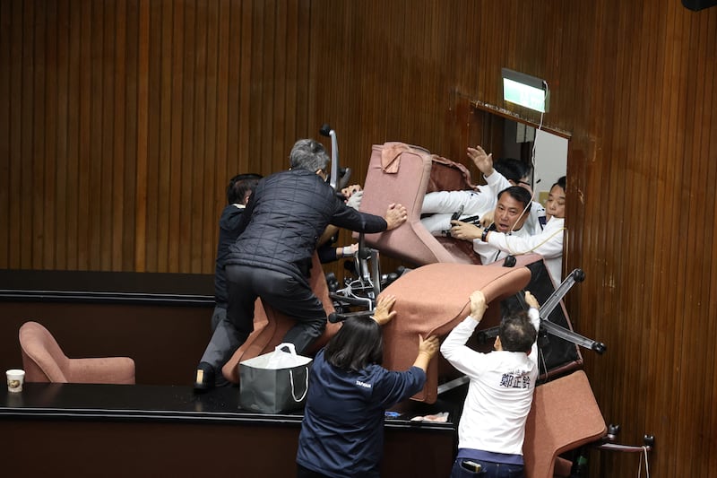 Lawmakers from the main opposition Kuomintang (KMT) (in white) try to break into Parliament where Democratic Progressive Party (DPP) occupied the night to avoid the passing of the third reading of amendments to the Civil Servants Election and Recall Act and other controversial bills at the Legislative Yuan in Taipei. Photograph: I-Hwa Cheng/AFP