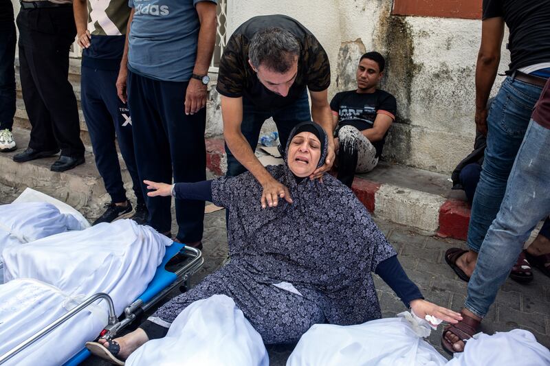 A woman mourns over the bodies of three of her siblings, killed in an Israeli air strike, at the Al-Shifa Hospital in Gaza City on Wednesday. Photograph: Samar Abu Elouf/New York Times
                      