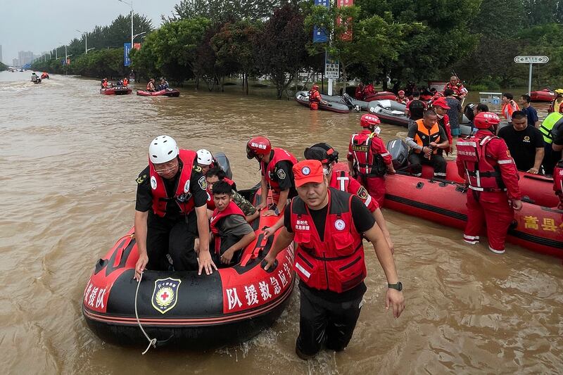 Residents evacuate on rubber dinghy boats through floodwaters in Zhuozhou, China. Photograph: Andy Wong/AP