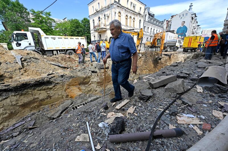 A pedestrian walks past employees working on a site of an overnight explosion in the centre of Kharkiv on June 6th. Photograph: Sergey Bobok/AFP via Getty