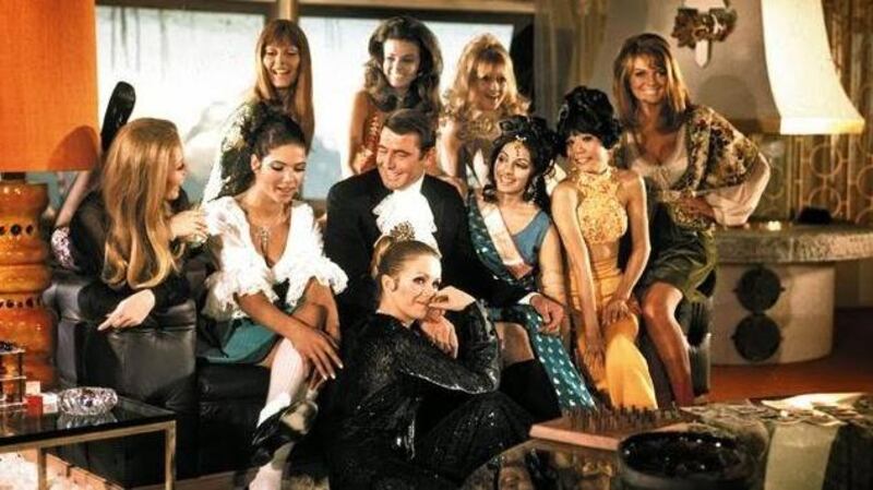 George Lazenby during filming of On Her Majesty’s Secret Service with actresses including Joanna Lumley, seated in front