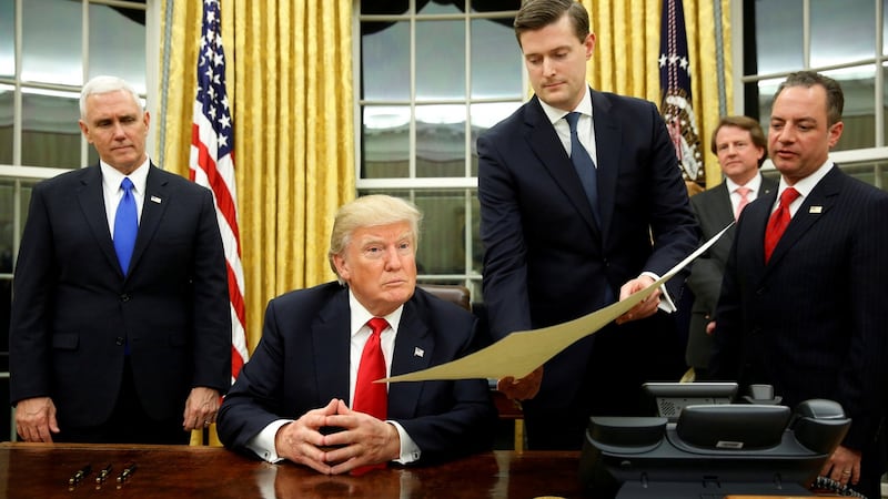 A file image from last month of former White House staff secretary Rob Porter (second right) gives Donald Trump, flanked by vice president Mike Pence (left) and chief of staff Reince Priebus (right), the document. Photograph: Reuters