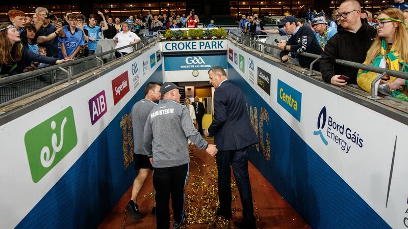 Gavin leaves the pitch with Dublin CEO John Costello after completing five-in-a-row. Photo: James Crombie/Inpho