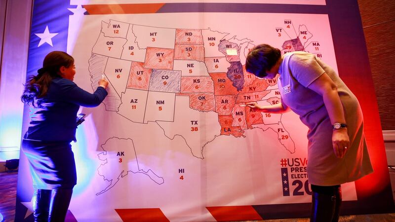 People colour in an electoral map during a US presidential election watch party at the US embassy in Ulaanbaatar, the capital of Mongolia, today.  Photograph: Byambasuren Byamba-Ochir/AFP/Getty