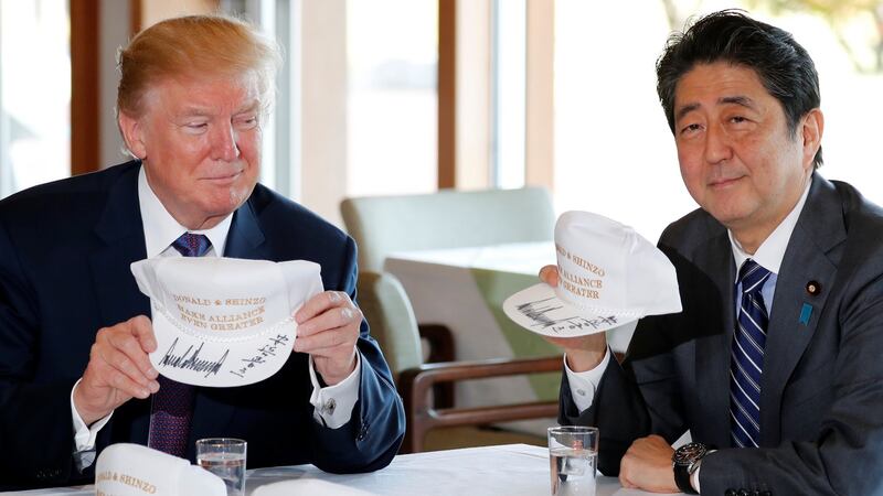 US president Donald Trump and Japan’s prime minister Shinzo Abe hold hats they signed, reading ‘Donald & Shinzo Make Alliance Even Greater’ before lunch and a round of golf in Kawagoe, Japan. Photograph: Reuters/Jonathan Ernst