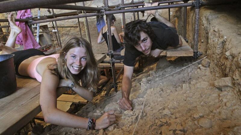 French volunteer archaeologists Camille Jacquey (16) and Valentin Loescher (20) pose in the Arago cave where the tooth was found. Photograph: Raymond Roig/AFP/Getty Images