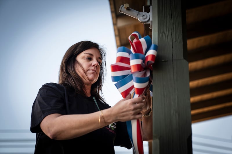 Jilliann Williams replaces holiday decorations with red, white and blue bows to honor former US president Jimmy Carter in Plains, Georgia. Photograph: Nicole Craine/New York Times
                      