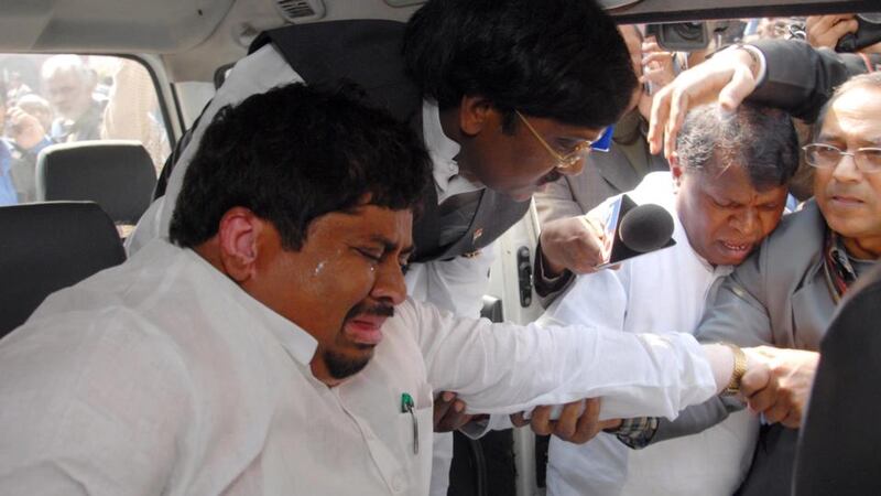 An  Indian politician is escorted from parliament after being affected by the pepper spray attack. Photograph: EPA