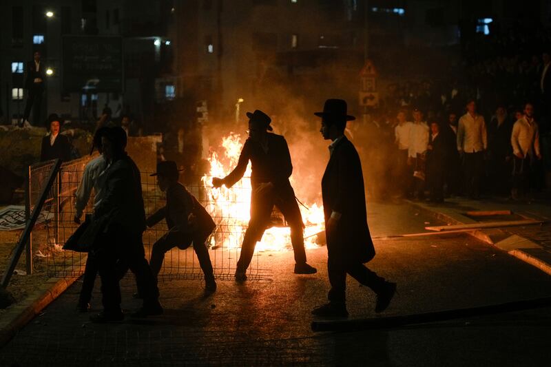 Ultra-Orthodox Jewish men burn rubbish during the protest in Jerusalem on Sunday. Photograph: Ohad Zwigenberg/AP