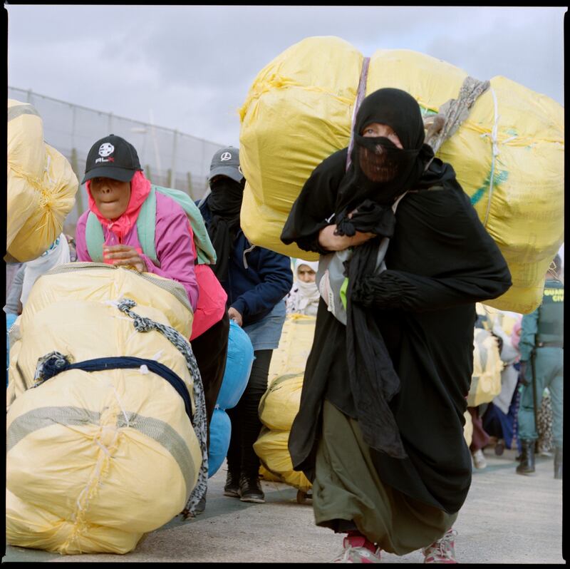 A Moroccan woman carries a package on her back at the Barrio Chino border crossing.