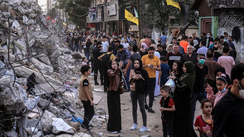 People walk by the rubble of a building destroyed by an Israeli air strike in Gaza City, on Friday. Photograph: Samar Abu Elouf/The New York Times