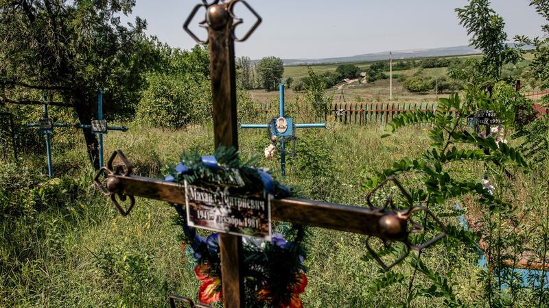 The graveyard in Dobrusa, Moldova is slowly receding into an undergrowth of nettles and bramble, grass flowers and cow parsley.  Photograph: Laetitia Vancon/The New York Times