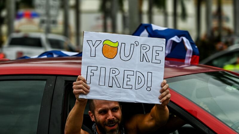 Supporters of the Democratic party show a placard to Trump supporters in Miami Photograph: CHANDAN KHANNA/AFP via Getty Images