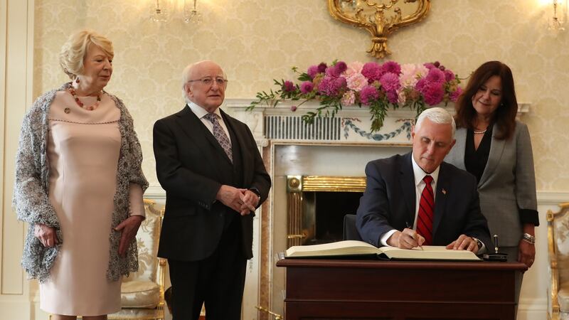 US vice-president Mike Pence signs the Visitors Book watch by wife Karen and Irish President Michael D Higgins and wife Sabina at Áras an Uachtaráin during his official visit to Ireland. Photograph: Liam McBurney/PA Wire