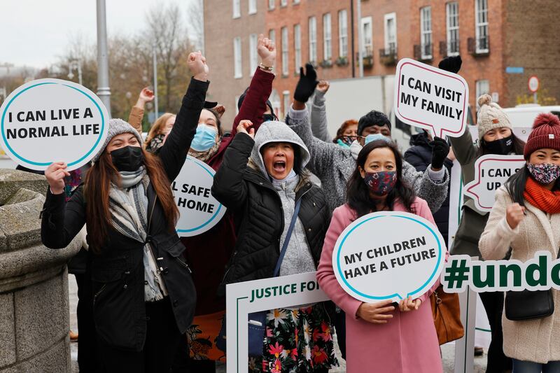 Shieryl Onda, Debra Sanipa and Karuna Thapa with others outside Government Buildings when the Government announced a regularisation scheme for the undocumented and asylum seekers: It was open to those who had spent at least four years in the State without immigration status or three years in the case of those with children. Photograph: Alan Betson 
