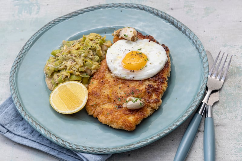 Chicken schnitzel with fried egg, garlic butter and creamed leeks. Photograph: Harry Weir