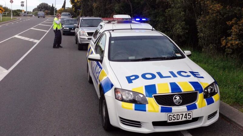 Cars line up behind a policeman at a road block near the epicentre of an earthquake located near the town of Seddon in the Marlborough region of  New Zealand today. Photograph: Anthony Phelps/Reuters.