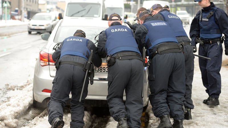 Members of the Garda Public Order unit give a push from the snow to the car carrying Mohammed Snew, who was remanded in custody leaving the Criminal Courts of Justice, in Dublin.Photograph: Dara Mac Dónaill