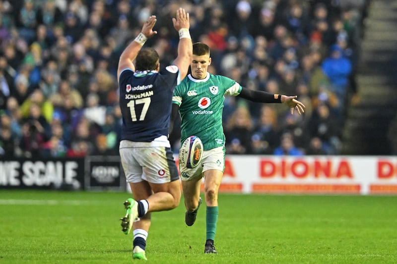 Ireland's outhalf Sam Prendergast kicks the ball on under pressure from Scotland's prop Pierre Schoeman. Photograph: Andy Buchanan/Getty         