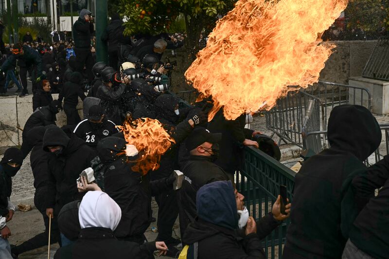 Protesters throw molotov cocktails towards riot police in front of the Greek parliament, in Athens, as clashes break out during a general strike to mark the second anniversary of the country's worst rail tragedy that left 57 dead on February 28th, 2023. Photograph: ARIS MESSINIS/AFP via Getty Images     