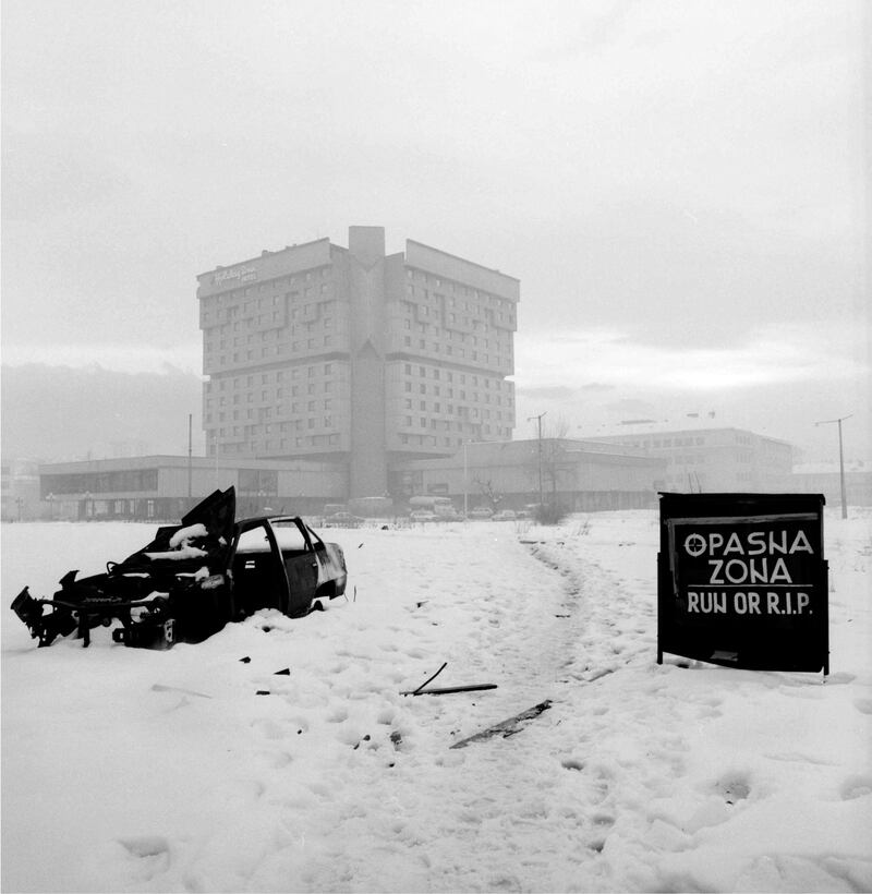 The Holiday Inn hotel, with a sign reading ‘Dangerous Zone – Run or R.I.P’, Sarajevo, Bosnia & Herzegovina. Photograph courtesy of Paul Lowe