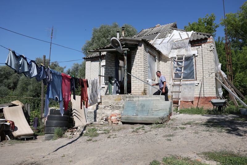 Local resident Oleksandr Prokopovich (58) works outside his damaged house in Mala Komyshuvakha village, in Kharkiv, Ukraine. Photograph: Anatolii Stepanov/AFP via Getty