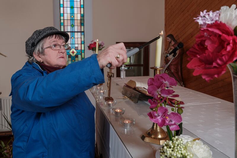 Anne Kett, a lay parishioner on Clare Island, lights candles at the altar in preparation for a Liturgy of the Word with Holy Communion. Photograph: Michael Mc Laughlin