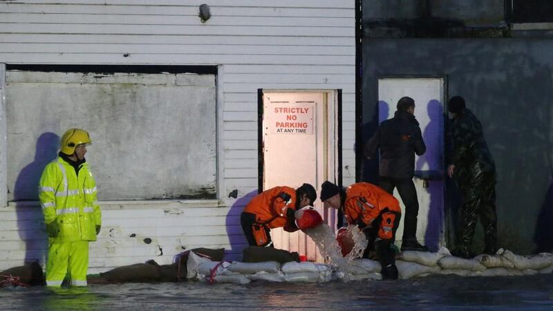 Members of the fire service and the army bail out water from shops in Ballybofey. Photograph: Niall Carson/PA Wire