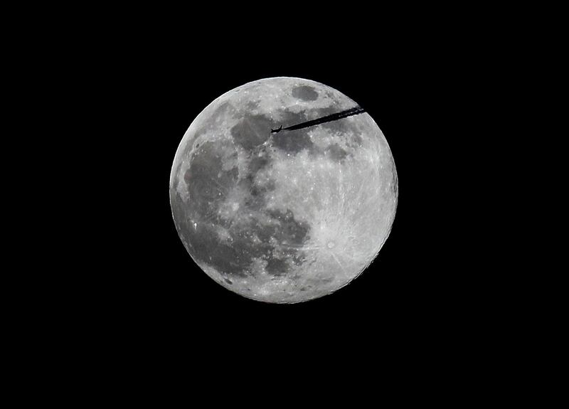 A plane passes the pink supermoon as it rises over Dublin. Photograph: Brian Lawless/PA