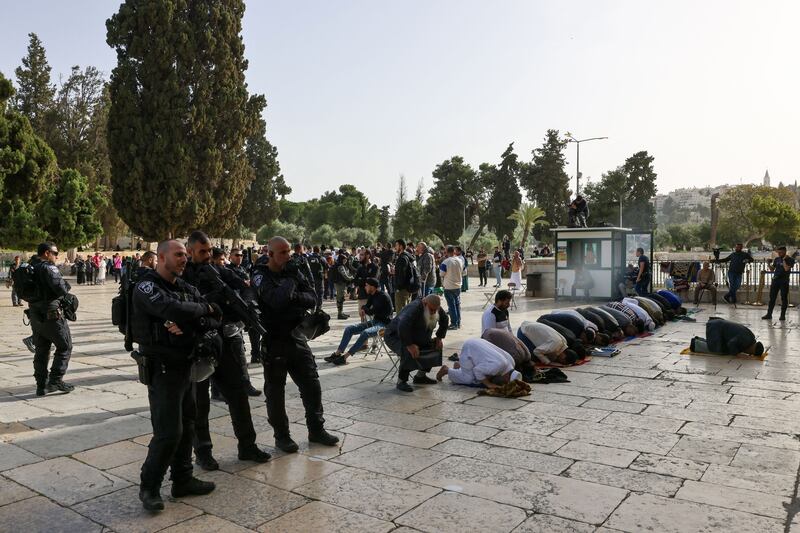 Muslim worshippers pray as Israeli security forces escort Jewish visitors at the Al-Aqsa mosque compound on Sunday. Photograph: Ahmad Gharabli/AFP/Getty