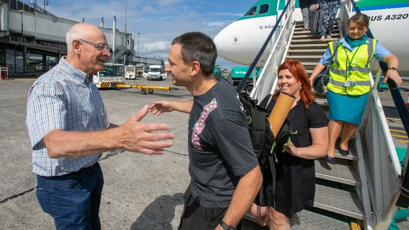 Ennis-based diver Jim Warny is greeted by his dad, Rene Warny, after he landed in Shannon Airport. Photograph: Arthur Ellis.