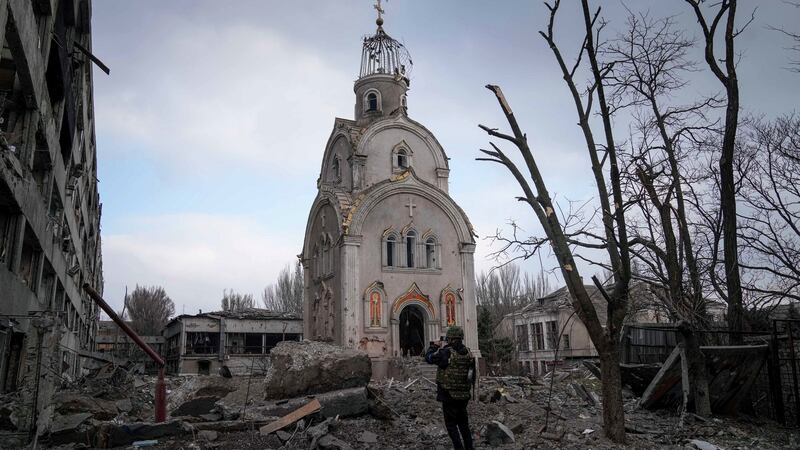 A Ukrainian serviceman takes a photograph of a damaged church after shelling in a residential district in Mariupol.  Photograph: AP Photo/Evgeniy Maloletka