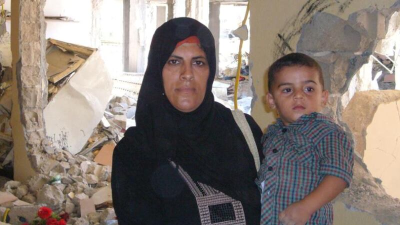 Sousan Najjar with one of her surviving children in the ruins of her house. Photograph: Lara Marlowe