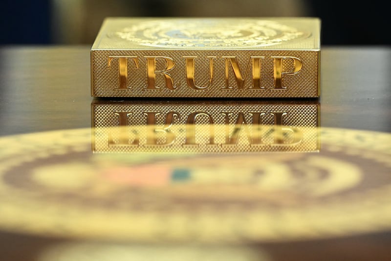 A gold 'Trump' coaster sits on the table in front of Mr Trump. Photograph: Mandel Ngan/ AFP         