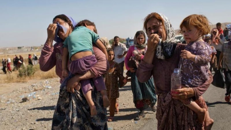 Iraqi Yazidi people, who fled their homes in Sinjar, enter Iraq from Syria at a border crossing in Feshkhabour in Dohuk province, northern Iraq, yesterday. Thousands of Yazidi fled their homes after Islamic State militants took control of Sinjar, and at least 500 Yazidis have been killed by Islamic State fighters, according to Iraq’s human rights minister. Photograph: Adam Ferguson/The New York Times