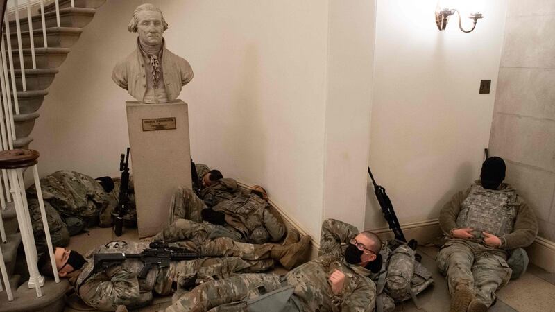 Members of the national guard take a rest in the Rotunda of the US Capitol in Washington on Wednesday. Photograph:  Saul Loeb/AFP via Getty Images