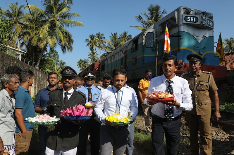 Railway workers and tsunami survivors carry flowers while attending the 20th anniversary commemoration of 2004 tsunami victims in the Peraliya suburb of Galle, Sri Lanka, on Thursday. Photograph: Chamila Karunarathne/EPA