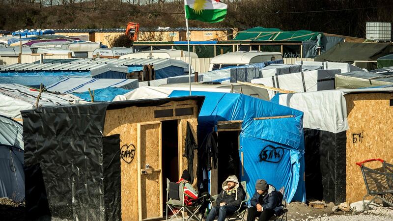 Men from Kurdistan sit in the sun outside their shelter on Friday in the Jungle migrants and refugee camp in Calais, northern France. Photograph: AFP